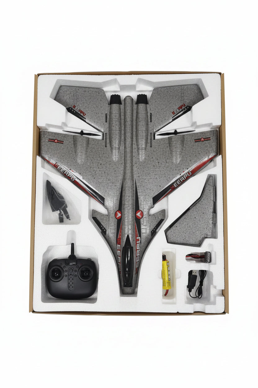 A remote-controlled model jet airplane in its white foam packaging tray, with a black remote controller and accessories visible on a tiled floor.